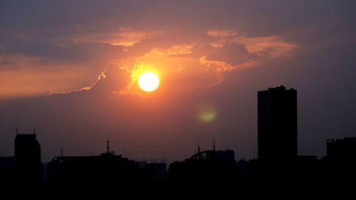 High section of silhouette buildings at sunset