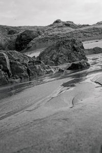 Surface level of rocks on shore against sky