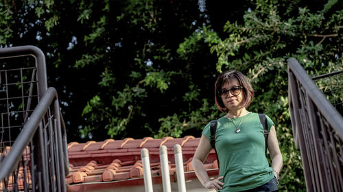 Portrait of smiling woman standing against plants