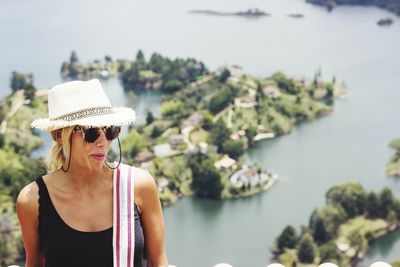 Woman wearing hat against lake