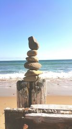 Stack of stones on beach against clear sky