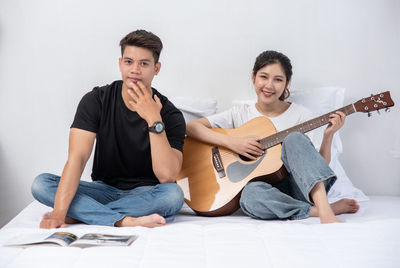 Portrait of a smiling young man holding guitar