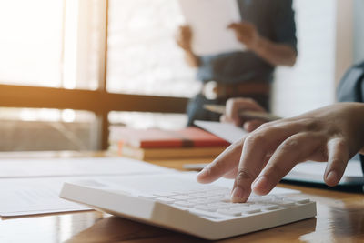 Midsection of man using laptop on table