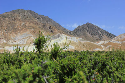 Scenic view of mountains against blue sky