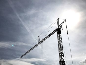 Low angle view of crane against sky