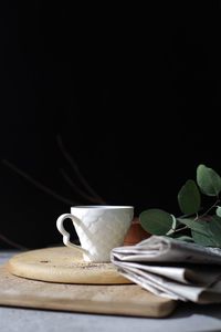 Coffee cup on table against black background