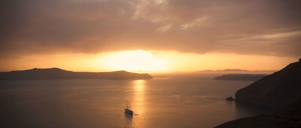 Ship sailing in sea against sky during sunset