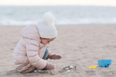 Rear view of woman drinking water at beach