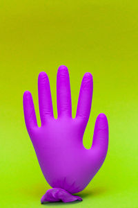 Close-up of hand against pink wall