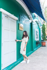 Portrait of woman standing against building