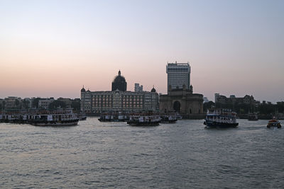 Buildings by sea against clear sky