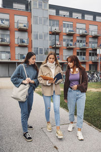 Friends standing against building