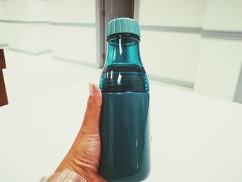 Close-up of hand holding bottle