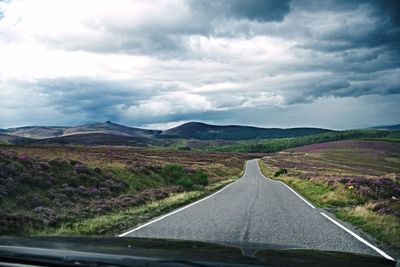 Road passing through landscape against sky