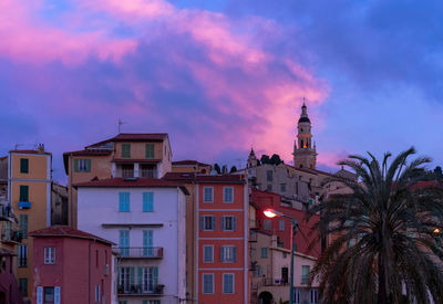 Low angle view of buildings against sky at sunset