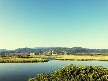 Scenic view of lake against clear blue sky