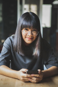 Portrait of smiling girl using mobile phone