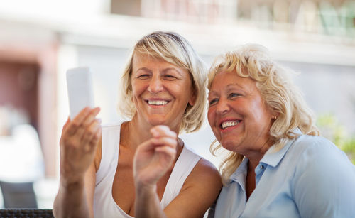 Happy senior female friends taking selfie