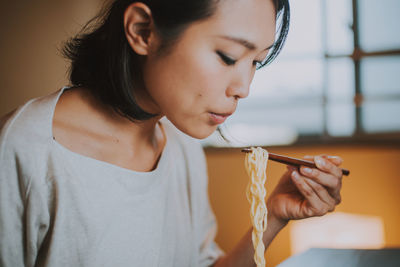 Beautiful woman eating food sitting at home