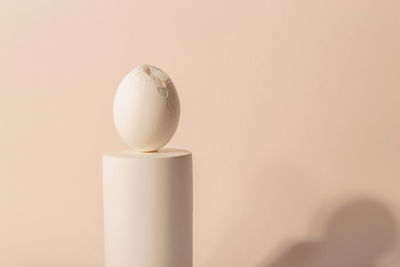 One white easter egg on a podium against a neutral background. minimalism and simplicity aesthetics