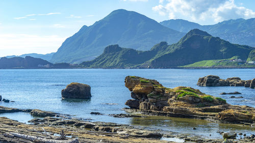 Scenic view of sea and mountains against sky