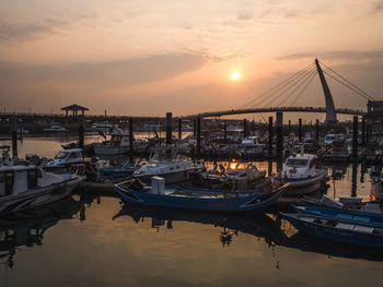 Boats moored in sea during sunset