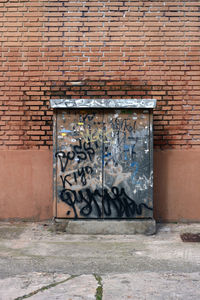 Graffiti on electric meter box against wall