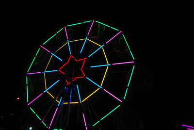 Close-up of illuminated lighting equipment against black background