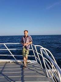 Full length of young man standing on boat deck