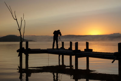 A photographer is capturing stunning sunrise at lake rotorua, new zealand
