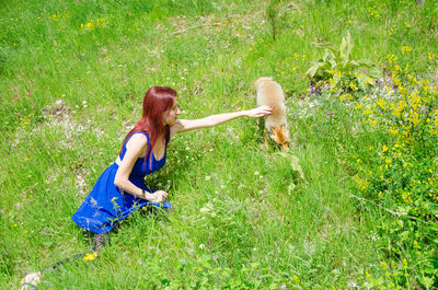 Woman touching fox on field