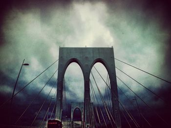 Low angle view of bridge against cloudy sky