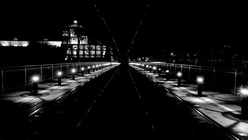 Illuminated bridge against sky at night