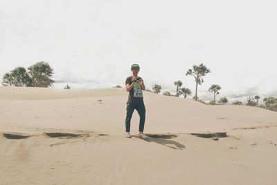 Full length of man standing on desert against sky