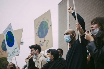 Male and female activist protesting for environmental issues during pandemic