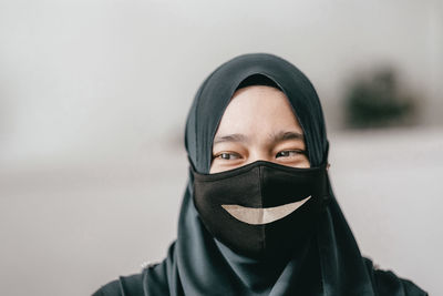 Close-up portrait of young woman covering face