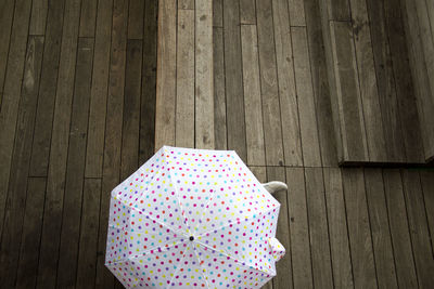 High angle view of person under umbrella on hardwood floor