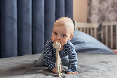 Portrait of baby playing on bed at home