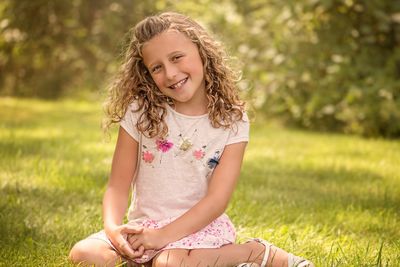 Portrait of smiling girl sitting on field