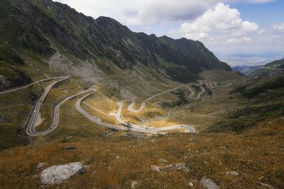 Scenic view of winding road in landscape against sky