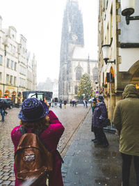 Rear view of people in city against sky