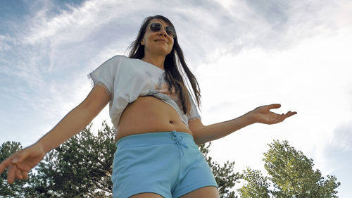 Low angle view of woman standing against sky