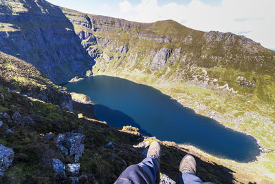 Low section of person on mountain by lake