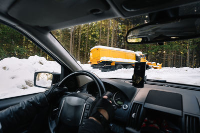 Man in car on winter mountain road