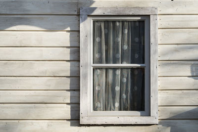 Close-up of window on wooden wall