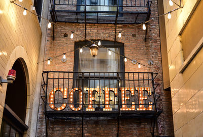 Low angle view of illuminated coffee text on balcony
