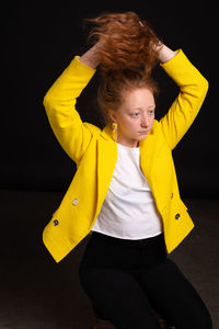 Portrait of woman with yellow hair against black background