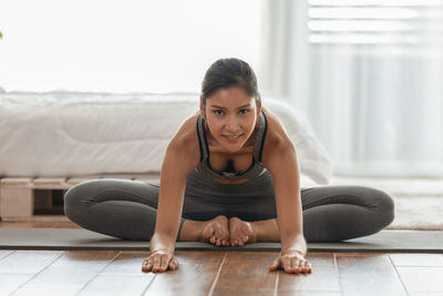 Portrait of young woman sitting on floor