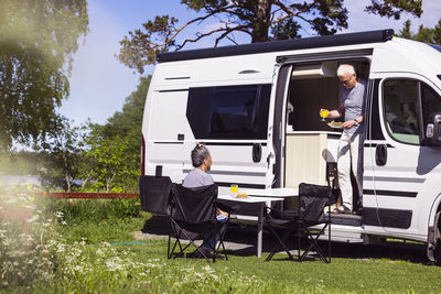 Senior couple having meal by camper van