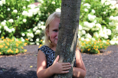 Close-up of girl hiding behind tree